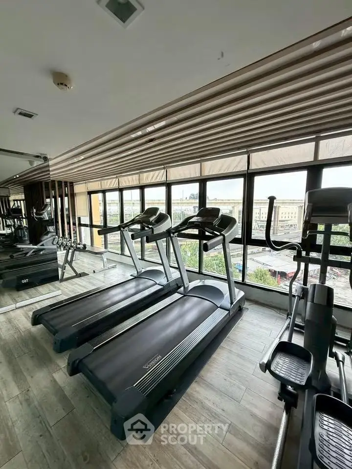 Modern gym with treadmills and large windows offering city views