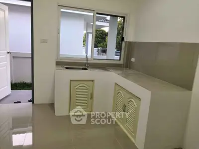 Modern kitchen with sleek countertops and large window for natural light.