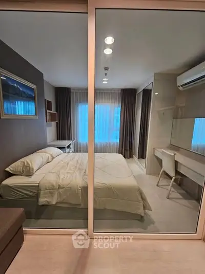 Modern bedroom with glass partition, stylish decor, and natural light.