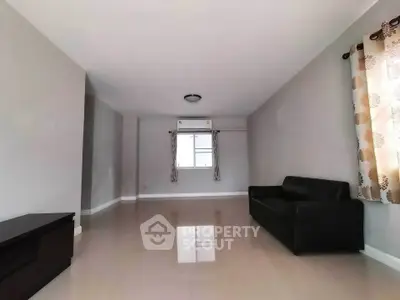 Spacious living room with sleek black sofa and modern decor