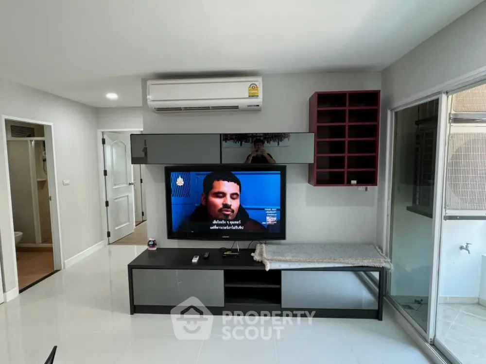 Modern living room with sleek TV setup and air conditioning unit