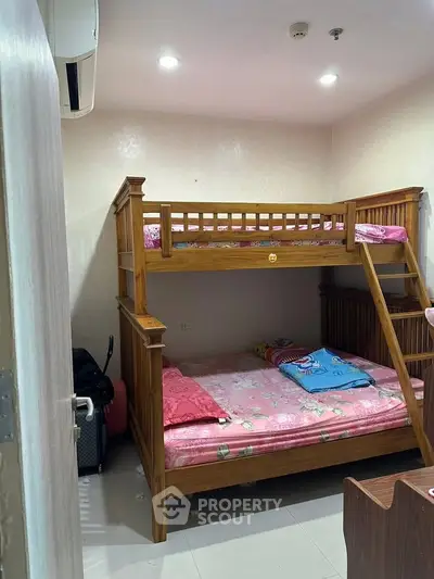 Cozy bedroom with wooden bunk bed and modern lighting, perfect for family living.