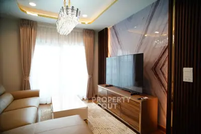 Luxurious living room with elegant chandelier and modern TV setup