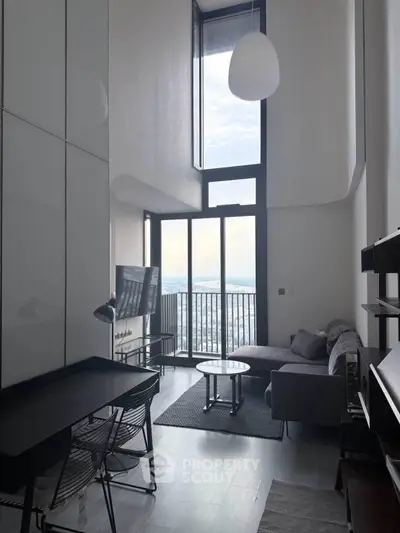 Modern living room with high ceilings and stunning city view from balcony.