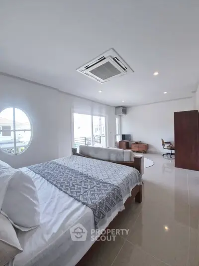 Spacious modern bedroom with large windows and stylish decor