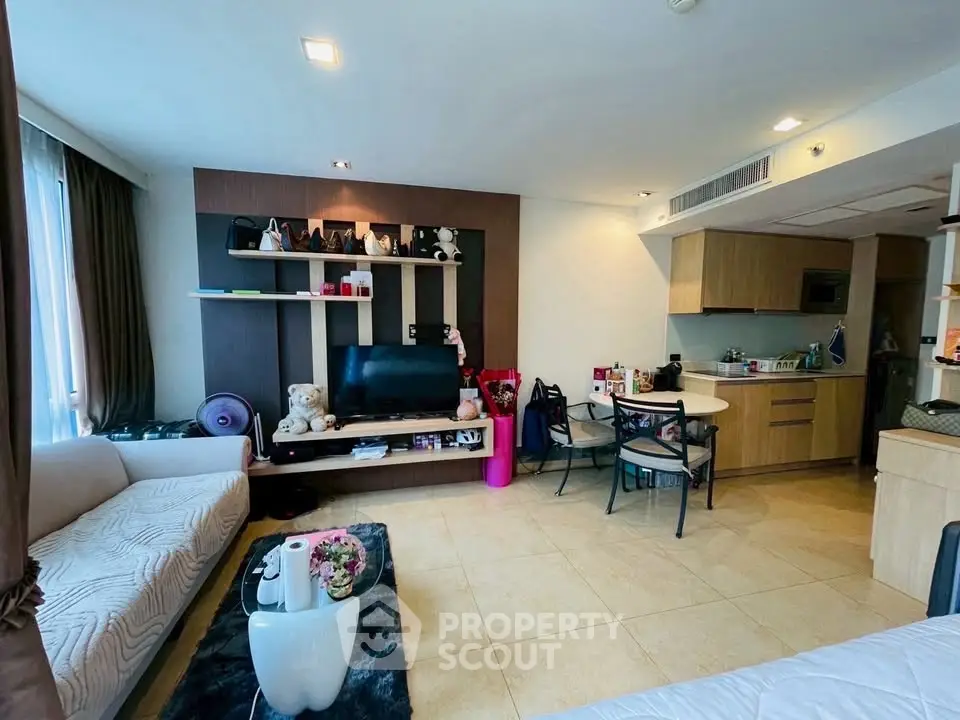 Modern living room with open kitchen, stylish decor, and cozy seating area