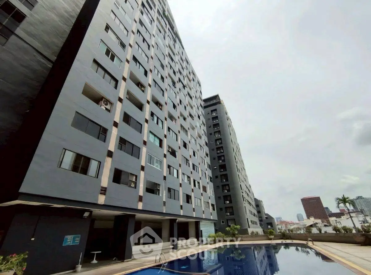 Modern high-rise building with pool and city view, ideal for urban living.