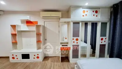 Modern bedroom with built-in storage and air conditioning, featuring sleek design and vibrant accents.