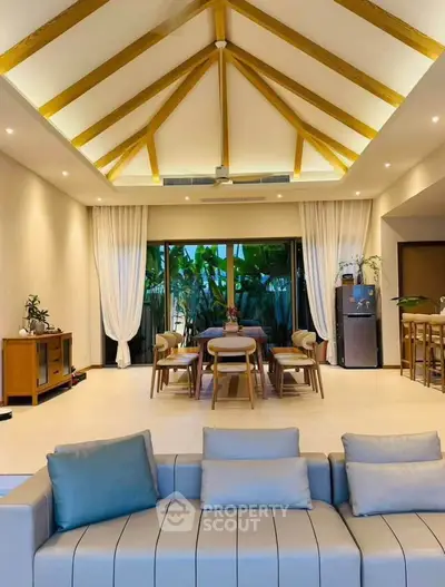 Luxurious living room with vaulted ceiling and elegant dining area, featuring modern furniture and lush garden view.