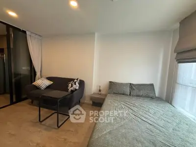 Modern studio apartment with cozy bed and stylish sofa in open layout.