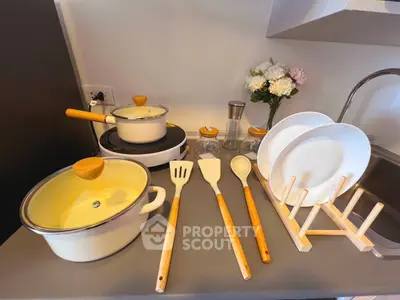 Modern kitchen setup with cookware and utensils on a sleek countertop.