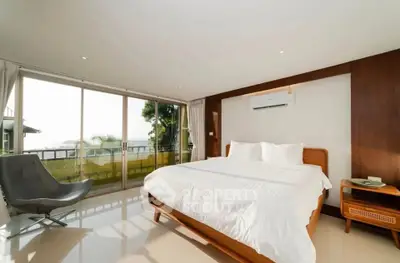 Spacious bedroom with large windows and modern furnishings offering a serene view.