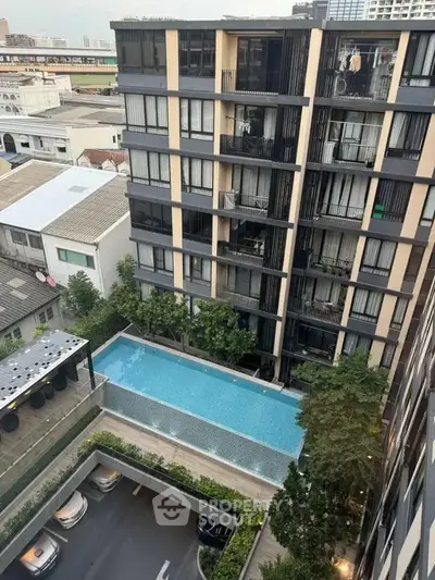 Modern apartment building with pool view and urban surroundings, ideal for city living.