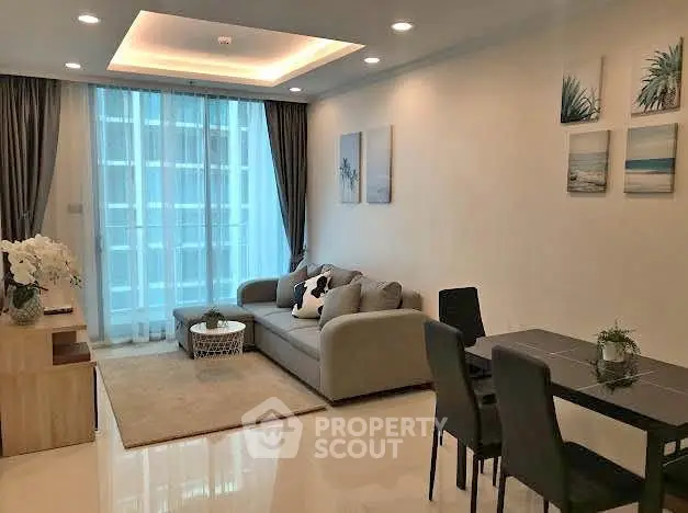 Modern living room with elegant decor and natural light, featuring a cozy sofa and dining area.