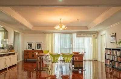 Spacious dining area with elegant lighting and polished wooden floors in a modern apartment.
