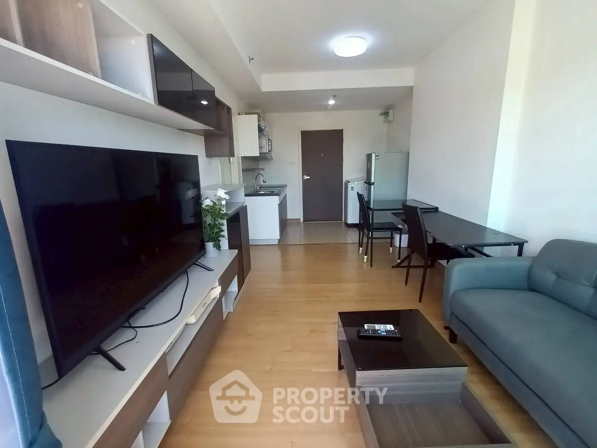 Modern living room with sleek furniture and open kitchen layout in a stylish apartment.