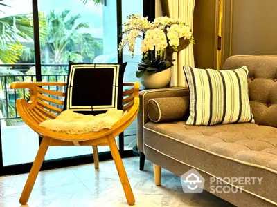 Stylish living room with modern chair and cozy sofa near large window with garden view.