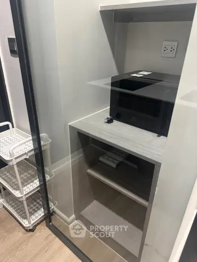 Compact storage area with microwave and shelving in modern home