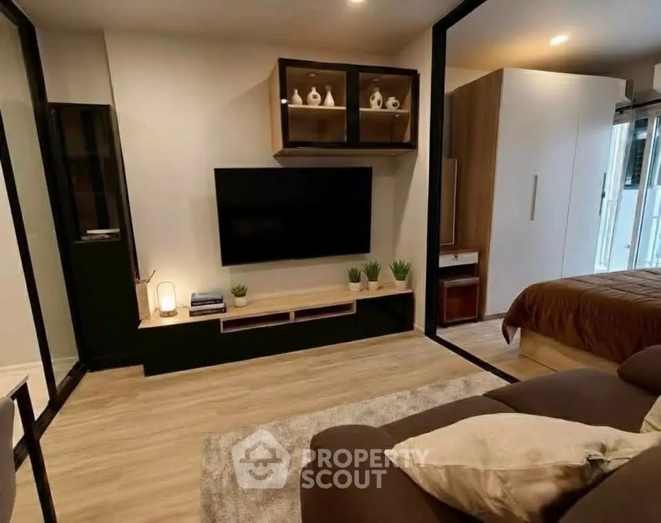 Modern living room with sleek TV setup and cozy seating area, perfect for relaxation and entertainment.