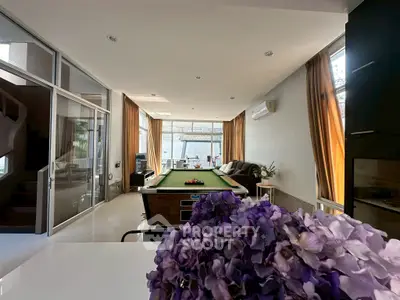 Spacious living room with pool table and modern decor, perfect for entertainment and relaxation.