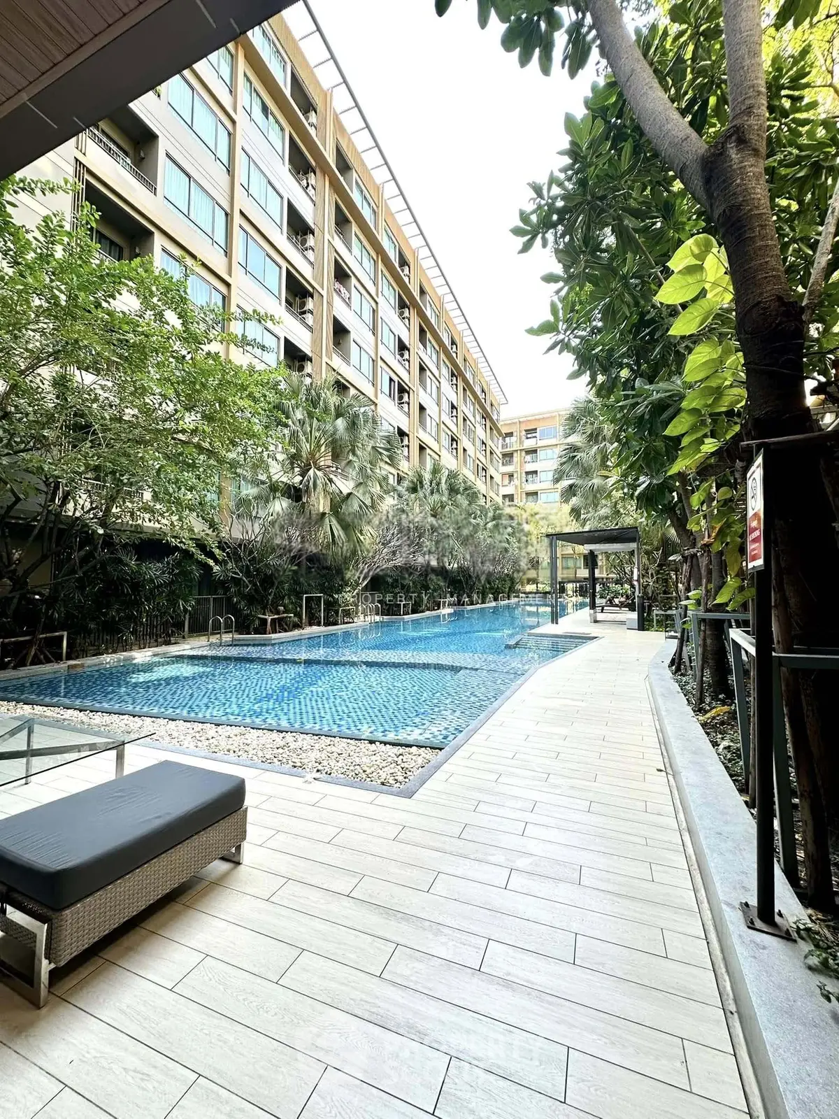 Luxurious apartment complex with stunning pool and lush greenery, perfect for relaxation and leisure.