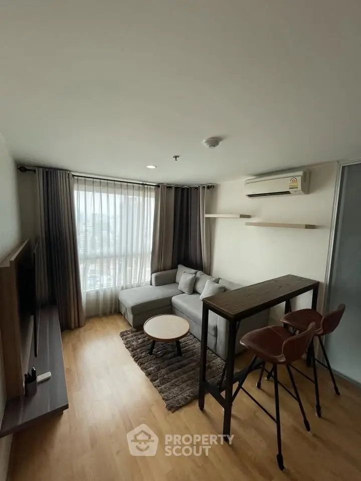 Modern living room with cozy sofa, stylish bar stools, and large window with city view.
