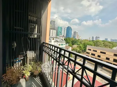Charming balcony with city skyline view and potted plants, perfect for urban living.