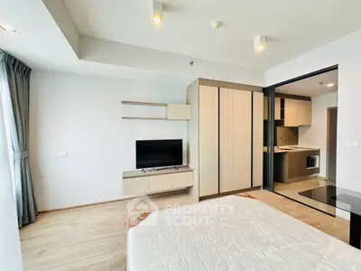 Modern bedroom with sleek design and open kitchen layout in a stylish apartment.