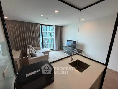 Modern living room with open kitchen and large windows in a stylish apartment.