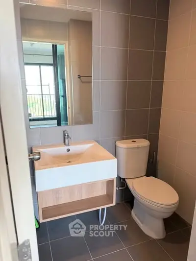 Modern bathroom with sleek fixtures and large mirror in a contemporary apartment.