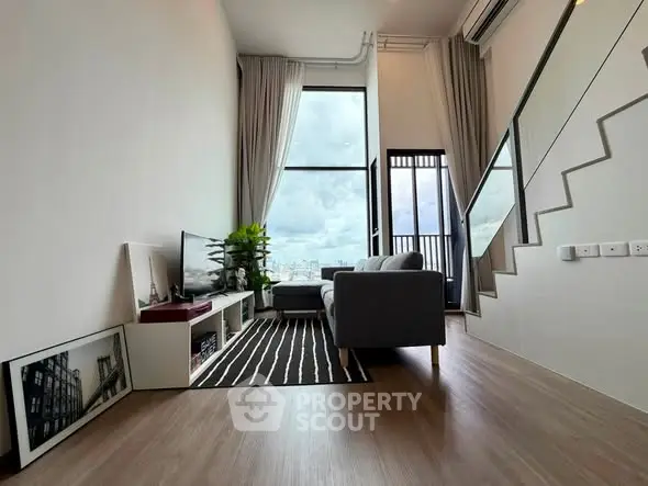 Modern living room with high ceiling and large window offering city views
