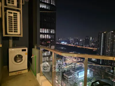 Stunning city view from high-rise balcony with washing machine and modern glass railing.