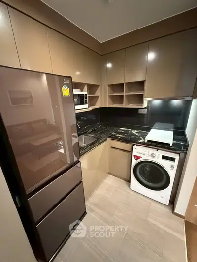 Modern kitchen with sleek cabinets, black countertop, and built-in appliances in a compact layout.