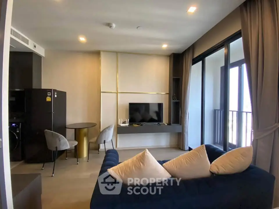 Modern living room with stylish decor and balcony access in a luxury apartment.