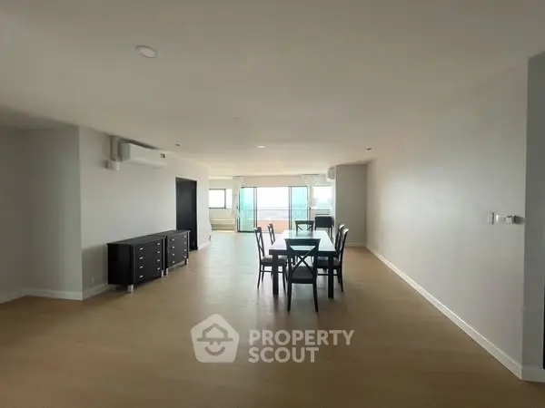 Spacious open-plan living and dining area with modern furnishings and large windows.