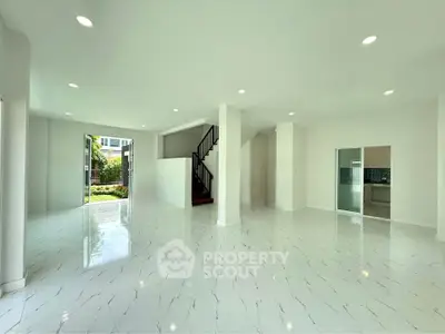 Spacious modern living room with glossy white flooring and open layout, perfect for family gatherings.