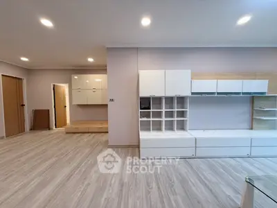 Spacious modern living room with sleek built-in storage and elegant lighting.