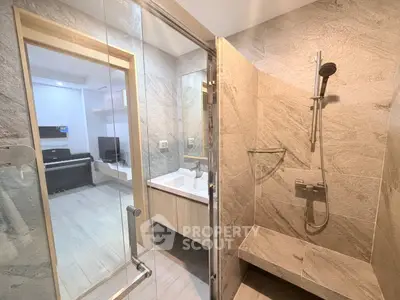 Modern bathroom with glass shower and view into living area