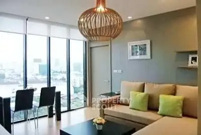 Modern living room with city view, stylish lighting, and cozy seating area.