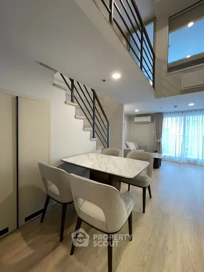Modern duplex living room with elegant dining area and stylish staircase