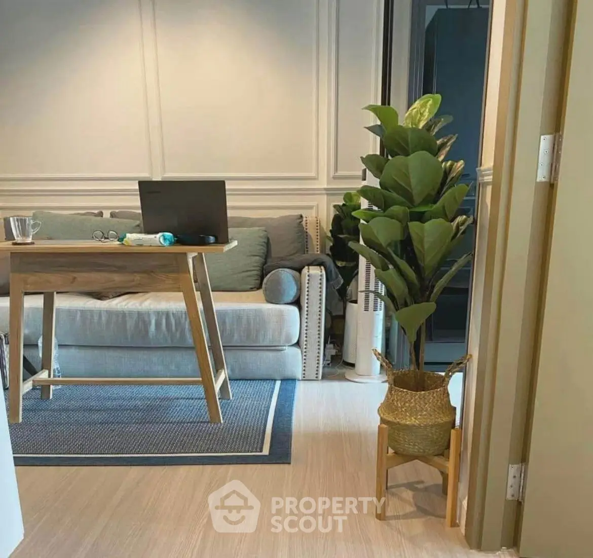 Cozy living room with modern decor and indoor plant, perfect for relaxation and work-from-home setup.