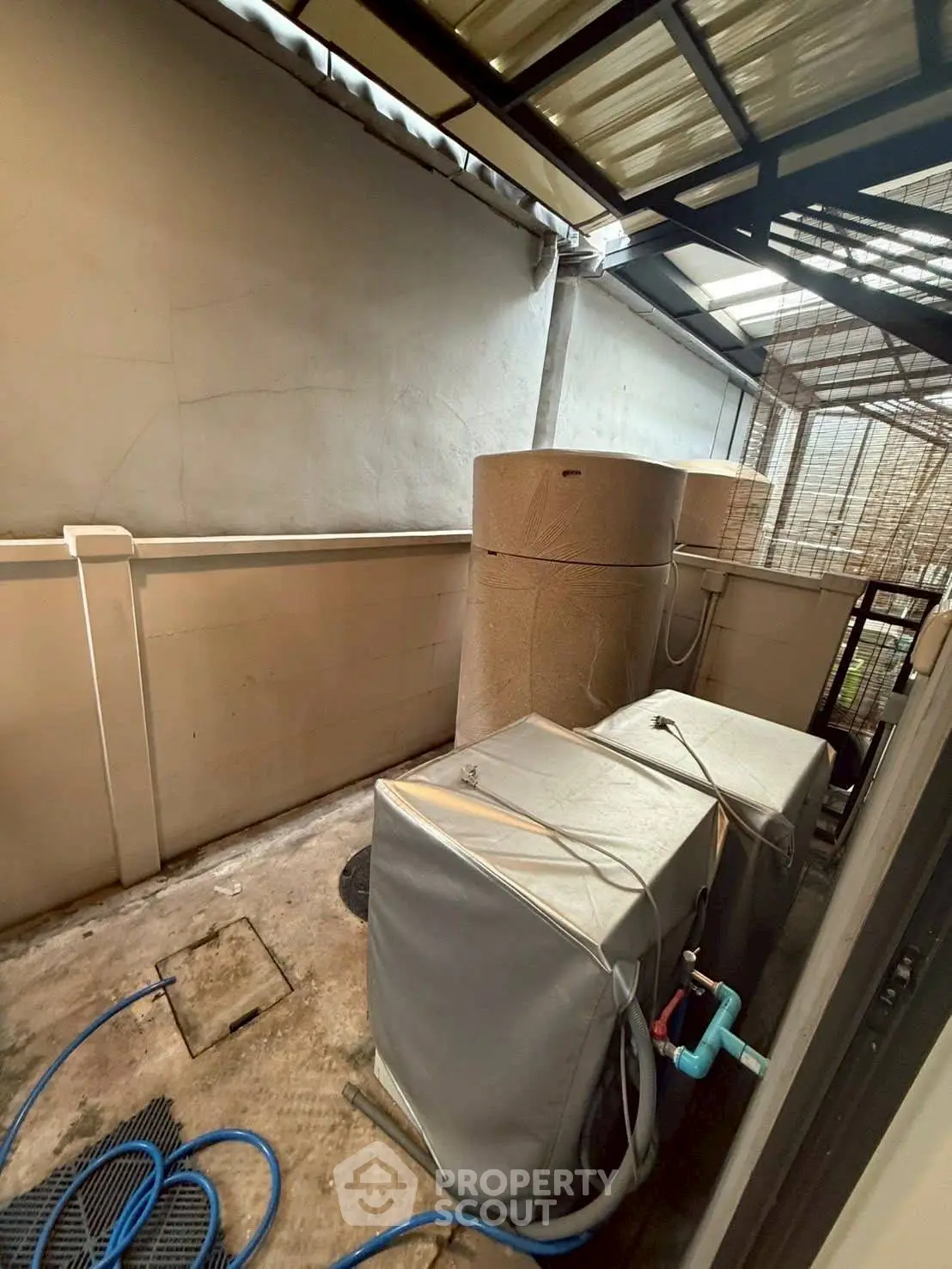 Outdoor utility area with water tanks and air conditioning units