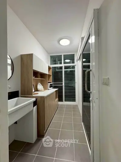 Modern kitchen with sleek cabinetry and large windows for natural light