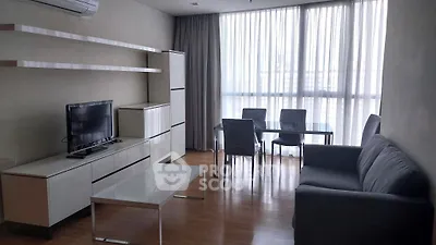Modern living room with sleek furniture and large windows offering natural light.