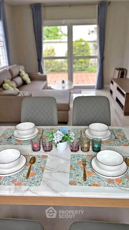 Elegant dining area with marble table and cozy living room view, perfect for modern family gatherings.