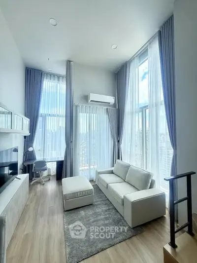 Spacious modern living room with high ceilings and large windows offering stunning city views.