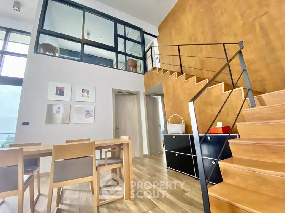 Modern duplex interior with wooden staircase and dining area