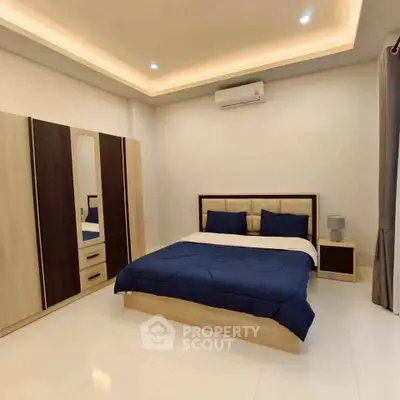 Spacious modern bedroom with elegant lighting and stylish furniture.
