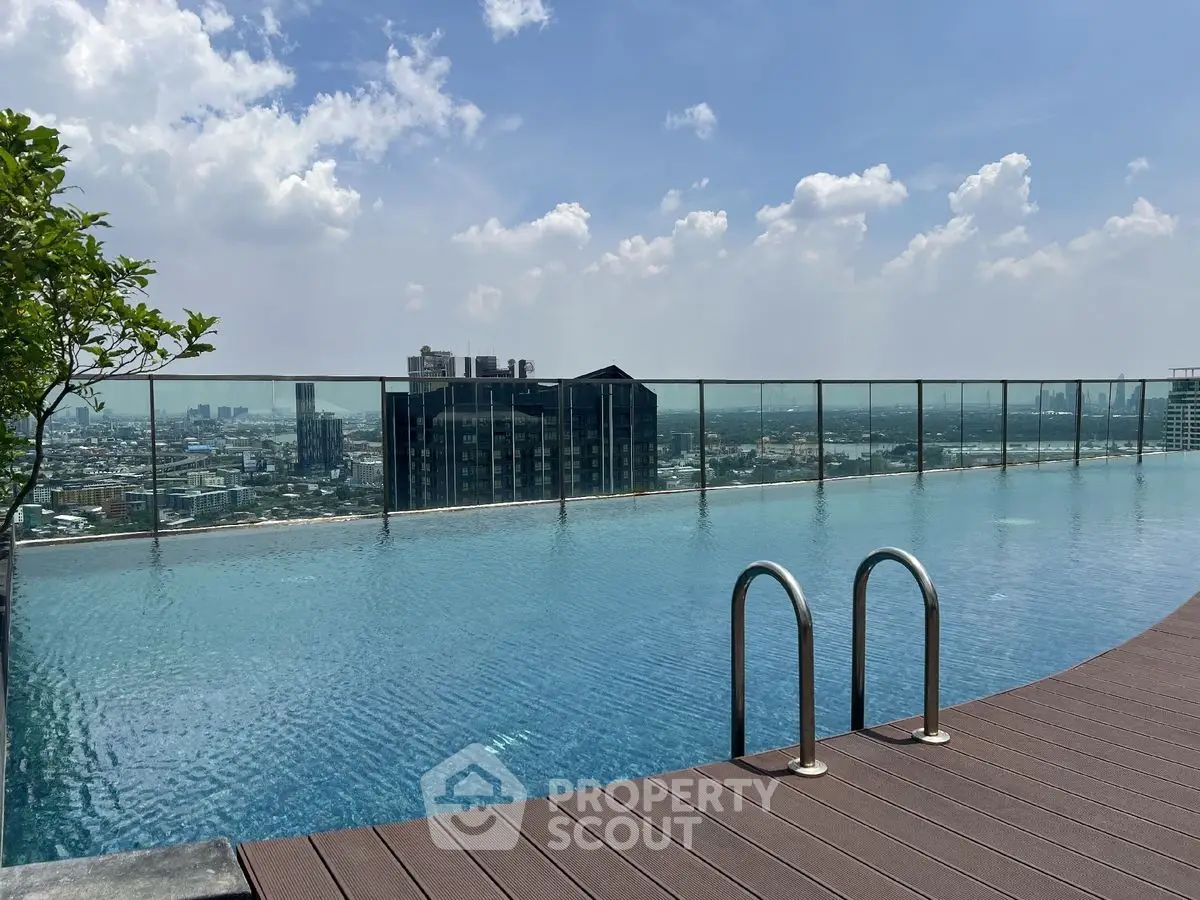 Stunning rooftop infinity pool with panoramic city views and clear blue skies.