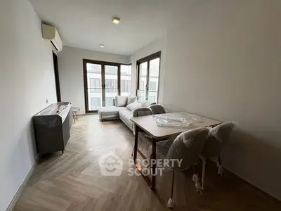 Modern living room with large windows and stylish furniture in a bright apartment.